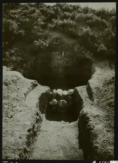 Tomb 20 at Marion during excavation, with a dug dromos leading to a cavity and a cluster of pale stones.