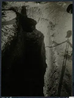 Tomb 26 at Marion during excavation, showing a deep narrow cut with a stone-edged opening in its side.