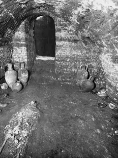 Interior of Tomb 22 at Marion with clay vessels on the floor and skeletal remains in the lower left