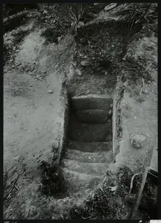 Dromos of Tomb 16 at Marion, a stepped passage cut down into the ground toward a tomb entrance.