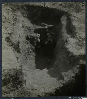 Tomb 29 at Marion during excavation, with a sloping cut leading down to a stone-filled tomb entrance