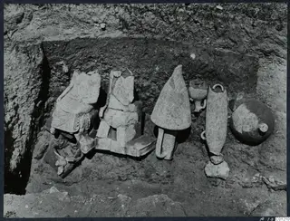 Stone sculptures and pottery lying in situ in excavated Tomb 30 at Marion