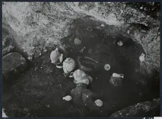 Tomb 42 at Marion during excavation, with pottery vessels and stones on the chamber floor