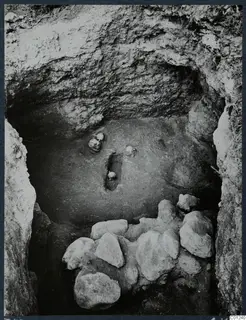 Tomb 49 at Marion during excavation, with vessels in the floor and a heap of stones across the front