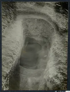 Excavation of Tomb 33 at Marion, with a dromos cut down to the dark opening of a tomb chamber