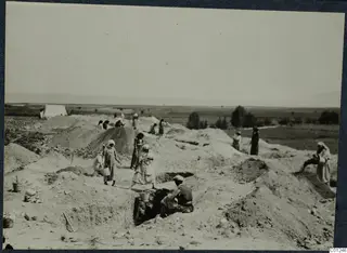 Workers digging the excavation at Marion, with spoil heaps, open trenches and a white tent on the left
