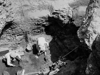 Work in progress at Tomb 37 at Marion, with workers digging inside a rock-cut pit.