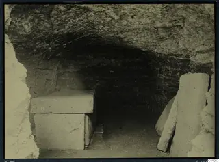 Interior of Tomb 34 at Marion with a rectangular stone sarcophagus and upright stone slabs beside it