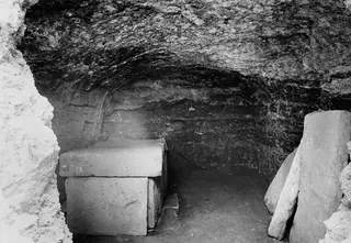 Interior of Tomb 34 at Marion with a stone sarcophagus in a rock-cut chamber