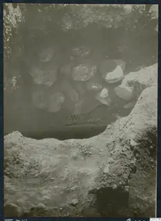 Excavation of Tomb 35 at Marion, with loose stones piled in the opening of the tomb cut