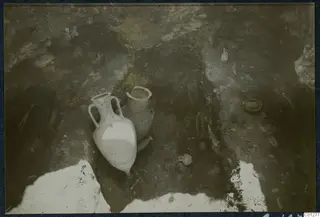 Two pottery vessels, an amphora and a jar, among small finds in an excavated tomb at Marion