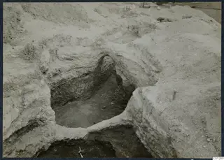 Excavated tomb 47 at Marion, a dug pit with a rounded opening in pale soil walls
