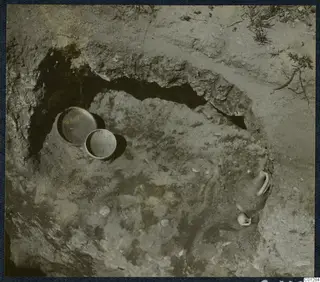 Tomb 31 at Marion during excavation, with two round vessels and a partly exposed vessel in the cut
