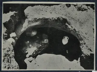 Tomb 59 at Marion during excavation, with objects and stones visible inside the tomb opening.