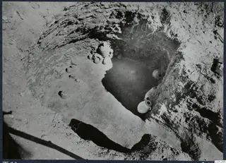 Tomb 62 at Marion during excavation, with pottery vessels lying in the pit and on the ground beside it