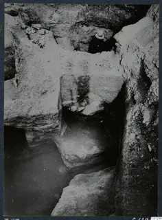 Excavation at Marion, Tomb 57, showing cut rock faces and a stepped cutting, with a person's hat visible at the top.