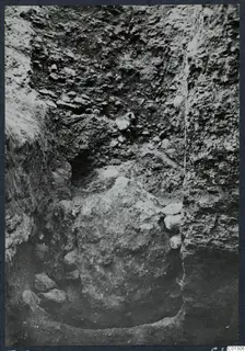 Excavation at Tomb 59 at Marion, with steep soil walls and loose stones in the cut