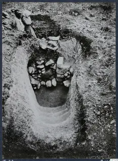 Tomb 73 at Marion: a stepped dromos leads down to a tomb entrance partly blocked by stacked stones