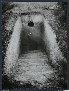 Tomb 72 at Marion: a sloping dromos with steps leading down to a tomb chamber containing objects