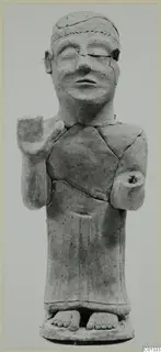 Terracotta statue of a standing human figure with one arm raised, shown cracked and repaired, against a plain background