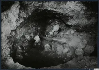 Interior of Tomb 67 at Marion, with pottery jugs and jars lying on the floor of the excavated chamber.