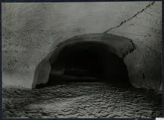 Vaulted rock-cut passage with a dark opening at the far end, on the Karpas peninsula