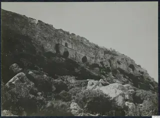 Steep rocky hillside on the Karpas peninsula with a flat-fronted recess and small doorway cut into the cliff face