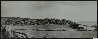 Panoramic view of Nitovikla on the Karpas peninsula, with scrubby hills, open ground and the sea on the right.