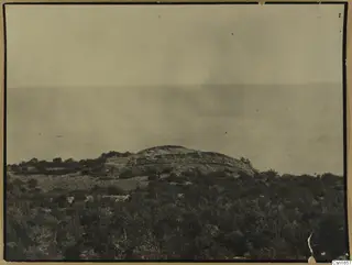 The fort at Nitovikla seen from the north-west: low stone walls on a hilltop above scrub and the sea.