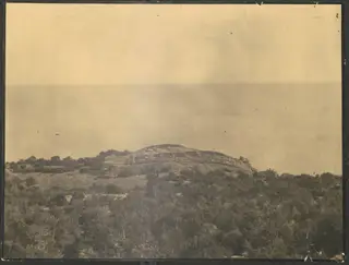 Nitovikla fort on a low hill above the sea, seen from the north-west across scrubby vegetation.