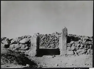 Entrance at Nitovikla between two tall upright stone jambs in a rough stone wall