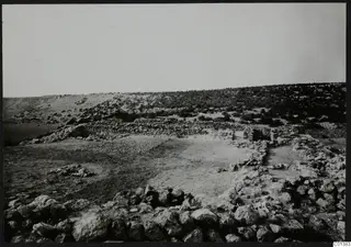 Stone walls and foundations at Nitovikla on the Karpas Peninsula, with scrubby hills rising behind.