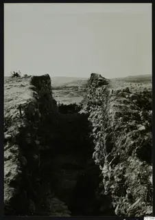 Excavation trench at Nitovikla between high stone-faced banks, with hills and a valley beyond