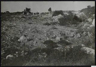 Rocky hillside with scrub and a group of people standing on the ridge at Nitovikla