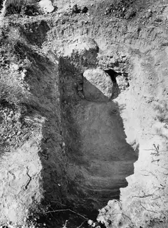 Tomb 2 exterior at Kountoura Trachonia, showing an excavated cut with a large boulder at its upper edge