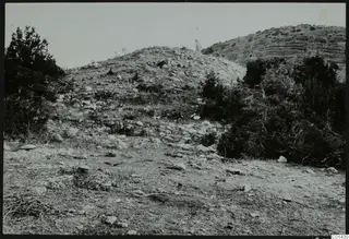 Stony mound with scrub bushes at Palaeoskoutella, seen from the south-west, with a small figure on the skyline