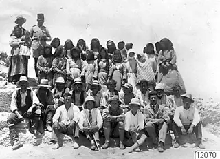 Work force posed in a large group on the last day of work at Vouni, men seated in front and women and children behind