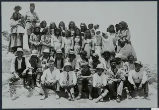 Group photograph of the work force at Vouni on the last day, men and women posed on a rocky slope.