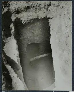 Tomb 5 at Ayios Iakovos during excavation, showing a tomb entrance with a flat stone slab across its lower part.