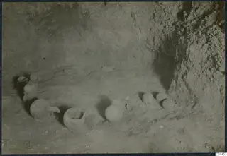 Pottery vessels lying on the sandy floor of Tomb 4.b at Ayios Iakovos during excavation