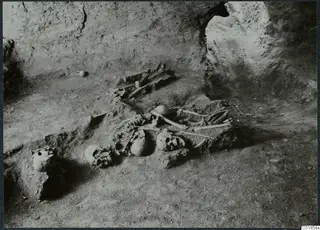 Skeletal remains and skulls on the floor of Tomb 14 at Ayios Iakovos during excavation
