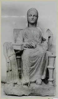 Seated stone statue of a woman on a throne with a rectangular plinth