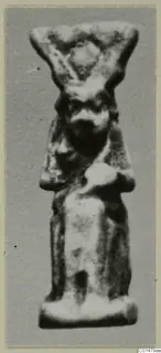 Small standing figurine with a broad headdress, folded arms and a bearded face, from the Marion finds