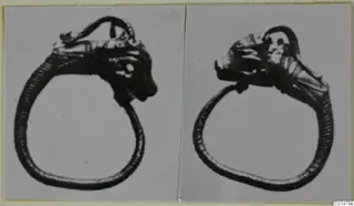 Two views of a gold ring with an animal-like head at the top