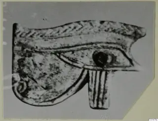 Eye-shaped amulet from Marion, Tomb 50, shown in a close photograph.