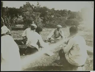 People sitting on bare ground among scrub at Nitovikla on the Karpas peninsula