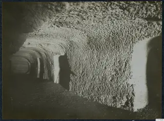 Interior of a rock-cut passage with a vaulted ceiling, chisel-marked walls and side openings, from the Karpas peninsula