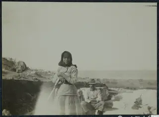 A girl and a man at the excavation of the theatre at Soli, with a long-handled tool in the foreground.
