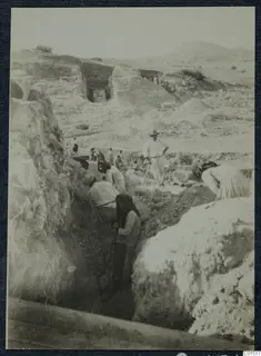 Excavation trench at the theatre at Soli, with workers digging between large stone blocks and walls.