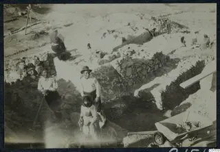 Excavation at the theatre at Soli, with exposed stone walls and workers digging among spoil heaps